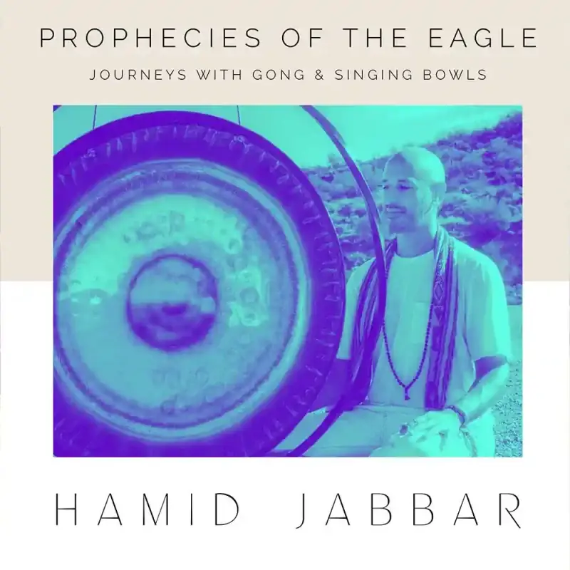 Cover art for Prophecies of the Eagle, a teal and purple duotone photograph of Hamid seated outdoors beside a large gong on a stand